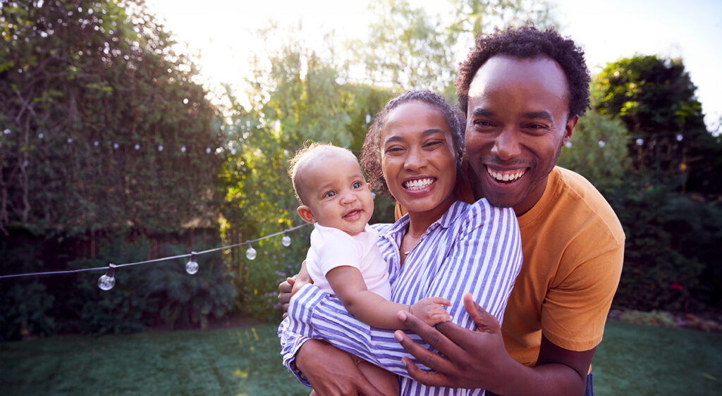 parents standing together holding infant