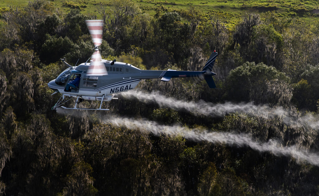 mosquito control helicopter spraying over area