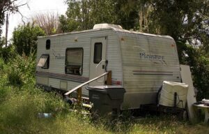 Betty Frey's mini-camper on her property surrounded by overgrown grass