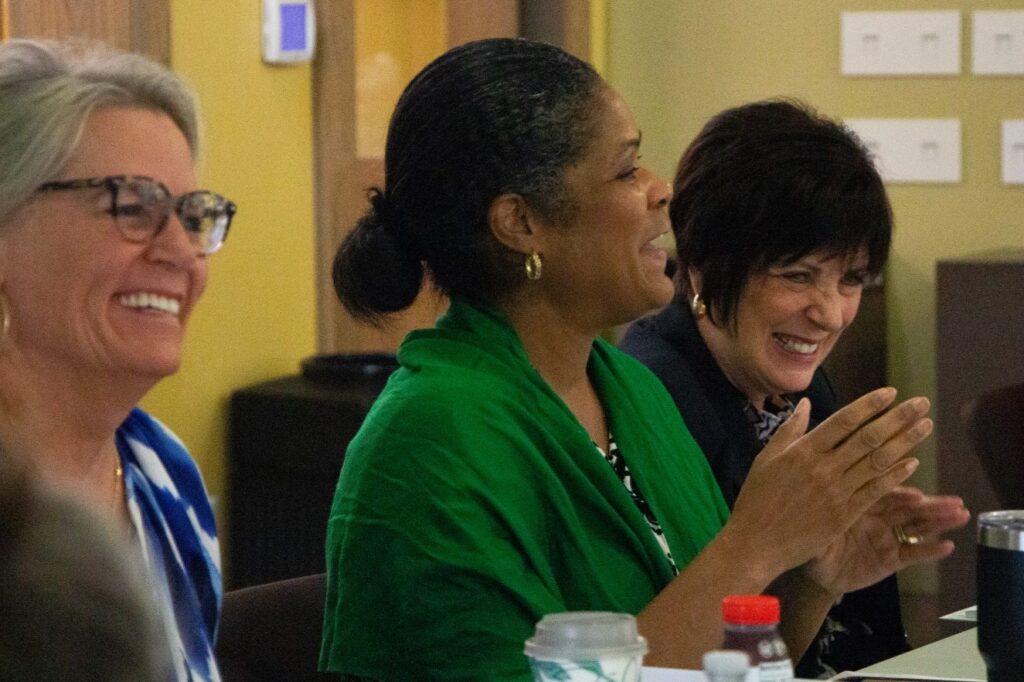 Three women sitting around table having a discussion