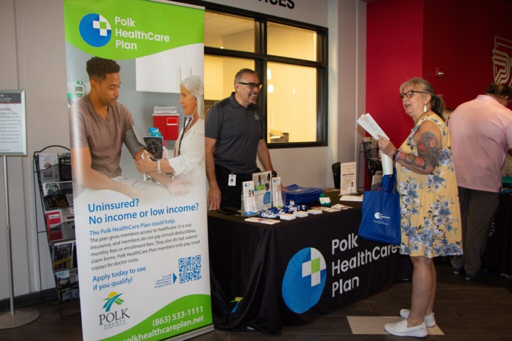 Polk HealthCare Plan outreach booth, man and woman talking