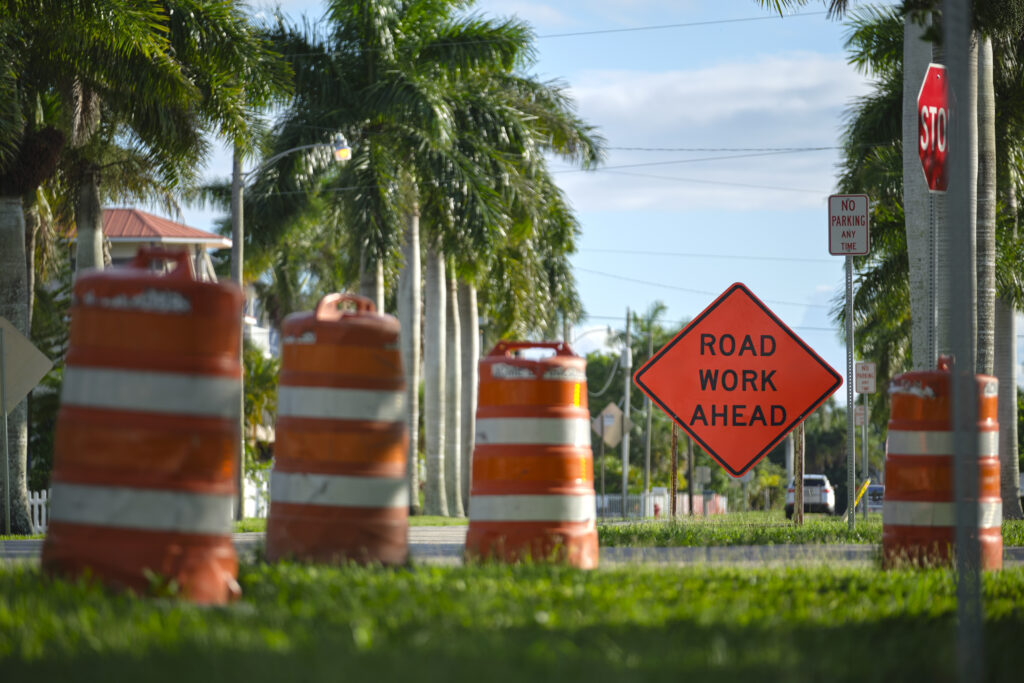 Road closed at construction site with protective fence barrier.