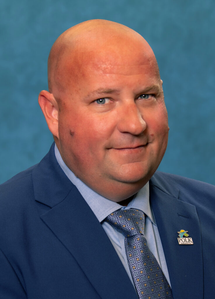 Headshot photograph of Brian Cogswell the Polk County Solid Waste Division Director wearing navy suit jacket with a Polk County Government logo pin.