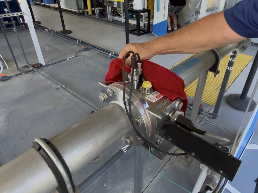 Buddy the Water Buddy wiping equipment with red cloth inside the Direct Potable Reuse Pilot facility in Polk County, Florida